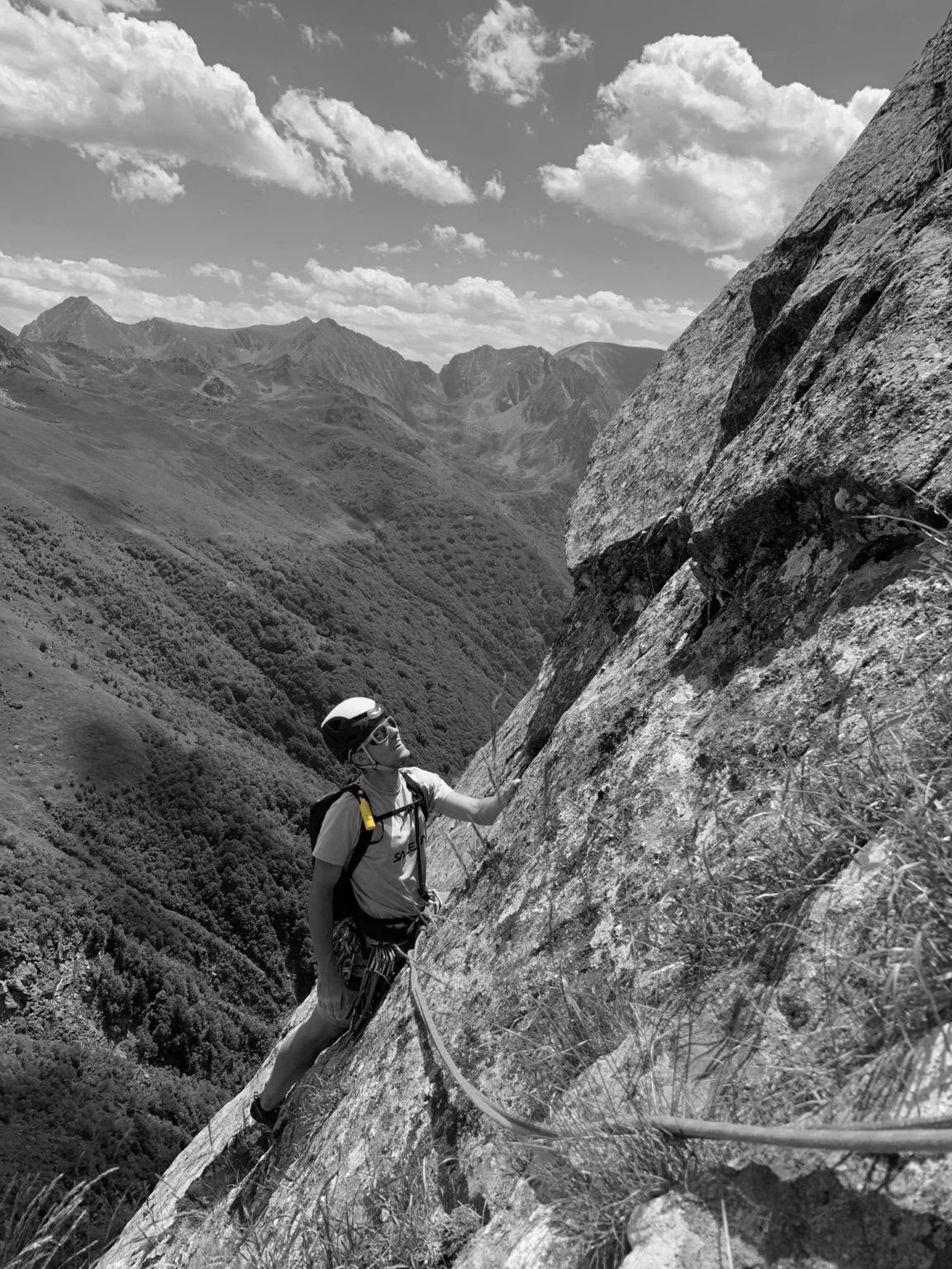 Una fotografía en blanco y negro de un escalador escalando una montaña. Lleva crema solar para escalada Nomad Face