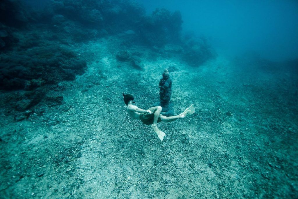 Un hombre buceando en el océano, usando un fotoprotector no perjudicial en los ecosistemas marinos