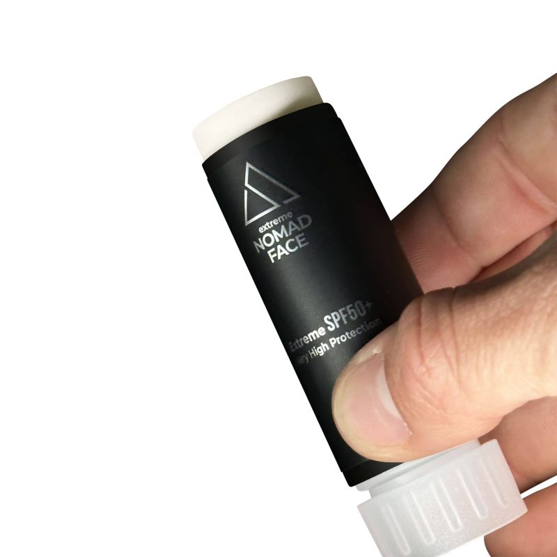 stick spf50+ mejor-proteccion-solar-facial Una mano sosteniendo un tubo negro de protector solar Nomad Face con factor de protección 50. El tubo está parcialmente abierto, mostrando la tapa blanca.